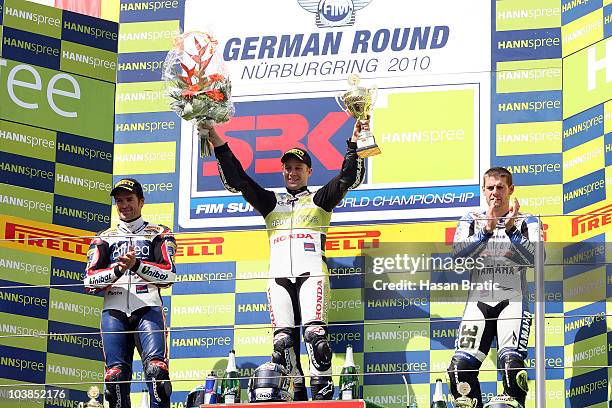 First placed Jonathan Rea of England and HANNspree Ten Kate Honda celebrates on the podium together with second placed Carlos Checa of Spain and...