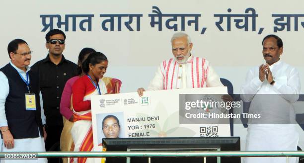 Prime Minister Narendra Modi gives a health card to beneficiaries as he launches Ayushman Bharat-National Health Protection Scheme, at Prabhat Tara...