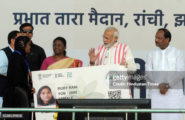 Prime Minister Narendra Modi gives a health card to beneficiaries as he launches Ayushman Bharat-National Health Protection Scheme, at Prabhat Tara...