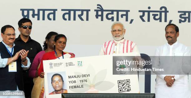 Prime Minister Narendra Modi gives a health card to beneficiaries as he launches Ayushman Bharat-National Health Protection Scheme, at Prabhat Tara...