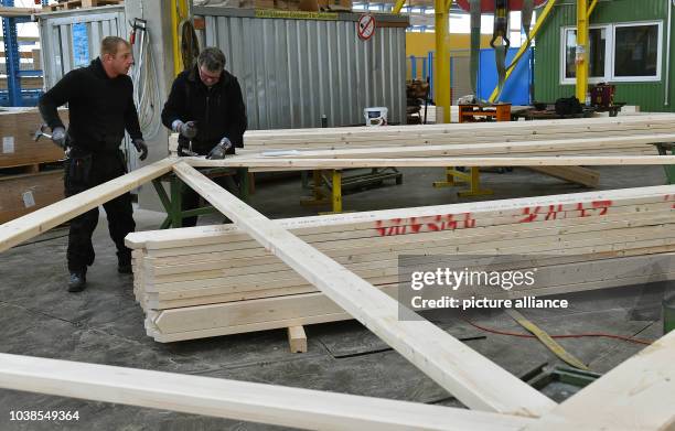 Carpenters work on a part of a roof structure at the company Opitz Holzbau GmbH in Neuruppin, Germany, 30 March 2016. The 65 employees of the company...