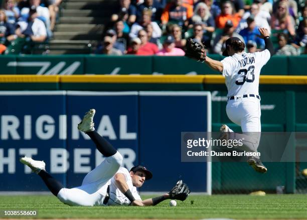 Left fielder Mikie Mahtook of the Detroit Tigers can't come up with a fly ball, avoided by shortstop Pete Kozma, off the bat of Cam Gallagher of the...