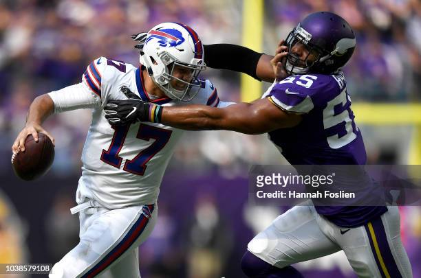 Josh Allen of the Buffalo Bills runs with the ball and stiff arms defender Anthony Barr of the Minnesota Vikings in the first half of the game at...