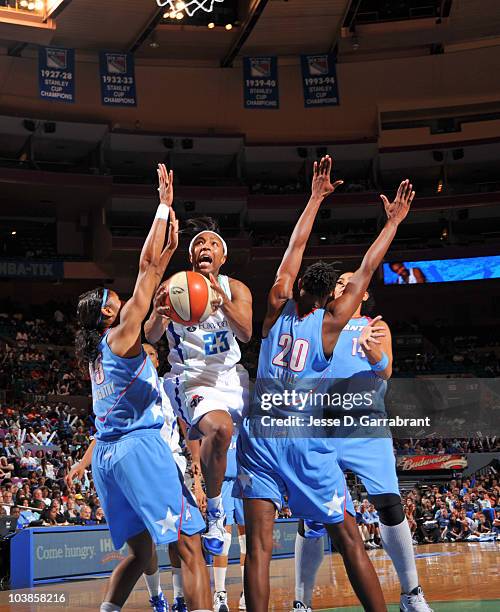 Cappie Pondexter of the New York Liberty shoots the basketball against Angel McCoughtry and Sancho Lyttle of the Atlanta Dream during Game One of the...