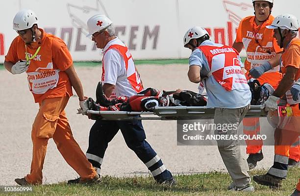 Rescuers carry Japanese rider Shoya Tomizawa of Technomag-CIP team on a stretcher after he crashed during the Italian Moto2 motorcycling race at...