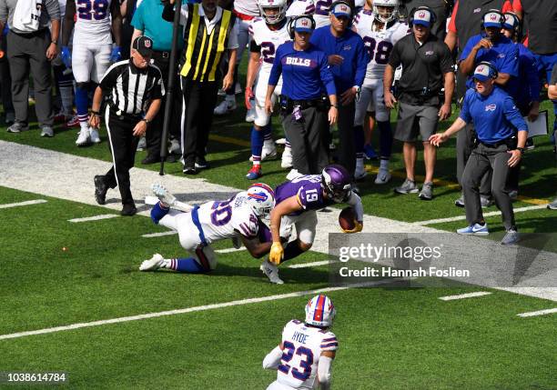 Adam Thielen of the Minnesota Vikings is tackled with the ball in front of the Buffalo Bills bench by Rafael Bush of the Buffalo Bills in the fourth...