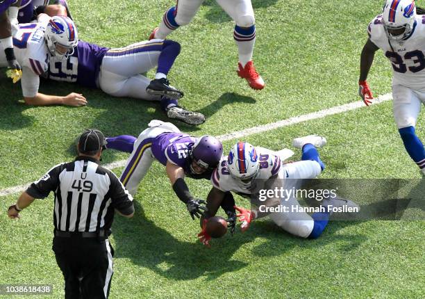 Harrison Smith of the Minnesota Vikings and Jason Croom of the Buffalo Bills dive for a loose ball after it was fumbled by Josh Allen in the third...