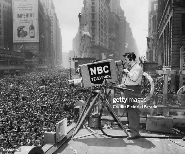 An NBC cameraman obtains shots of the massive crowd gathered in Times Square from the roof of a building in New York City, New York, USA, circa 1945....