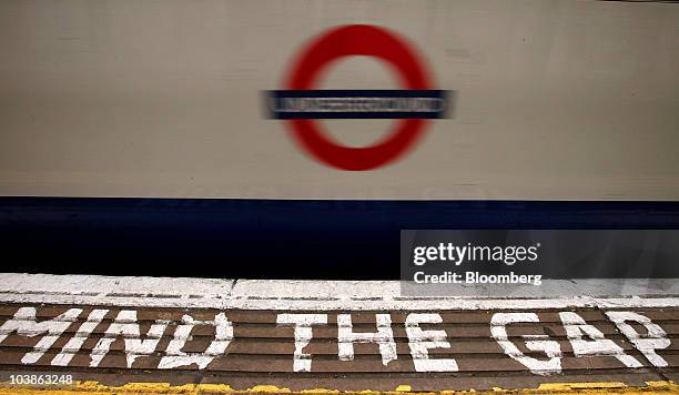 Platform sign reading "mind the gap" warns passengers traveling on the London Underground in London, U.K., on Monday, Sept. 6, 2010. London's 3.5...