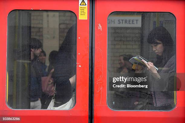 London Underground passenger reads while traveling on board a Tube train in London, U.K., on Monday, Sept. 6, 2010. London's 3.5 million Tube...