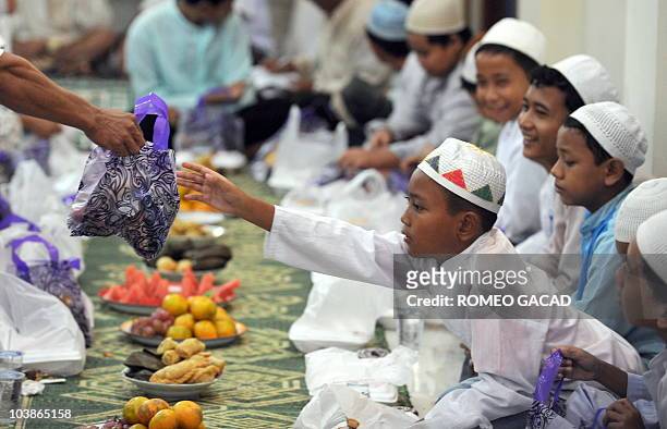 In this photograph taken September 5, 2010 Indonesian Muslim children and youths from poor families receive a bag of gifts before they partake in an...
