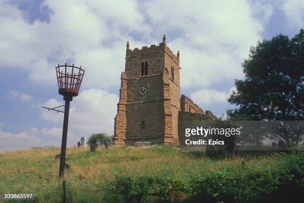 General view of All Saints church, also known as the ramblers church, and the beacon outside which was erected in 1988 to commemorate victory over...