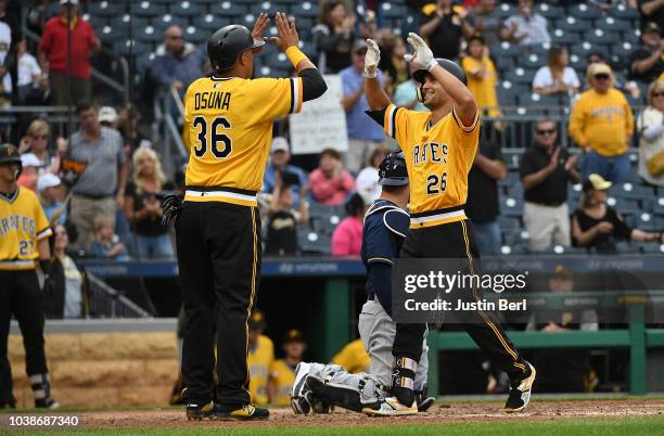 Adam Frazier of the Pittsburgh Pirates high fives with Jose Osuna after hitting a two run home run in the ninth inning during the game against the...