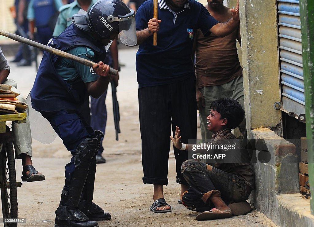 A Bangladeshi policeman hits a child wit