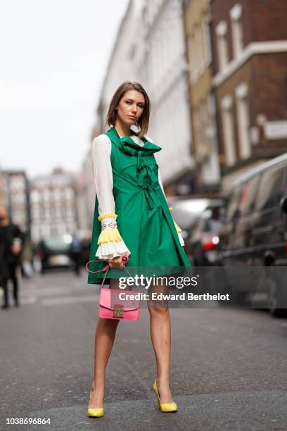 Landiana Cerciu wears a green dress, a pink Furla bag, white ruffled sleeves, during London Fashion Week September 2018 on September 16, 2018 in...