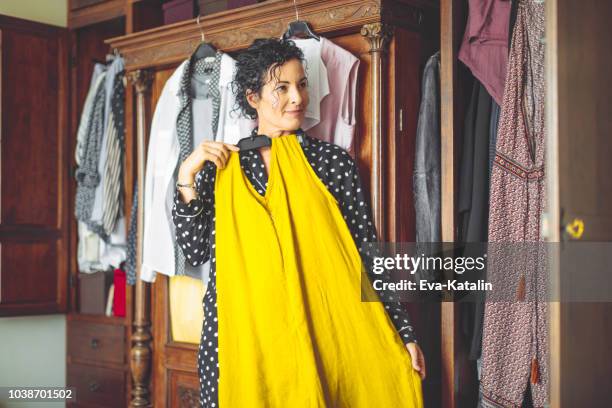 woman is choosing the right dress to wear - getting ready stock pictures, royalty-free photos & images