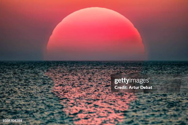idyllic sunrise with huge sun rising over the sea. - cielo romantico foto e immagini stock