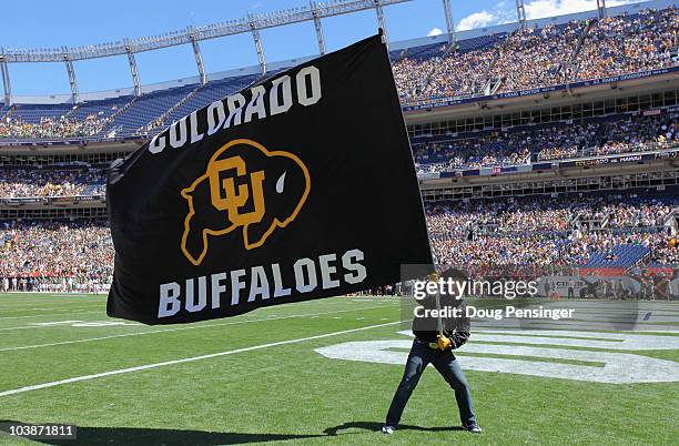 Supporter of the Colorado Buffaloes waives a flag in the endzone against the Colorado State Rams in the Rocky Mountain Showdown at INVESCO Field at...