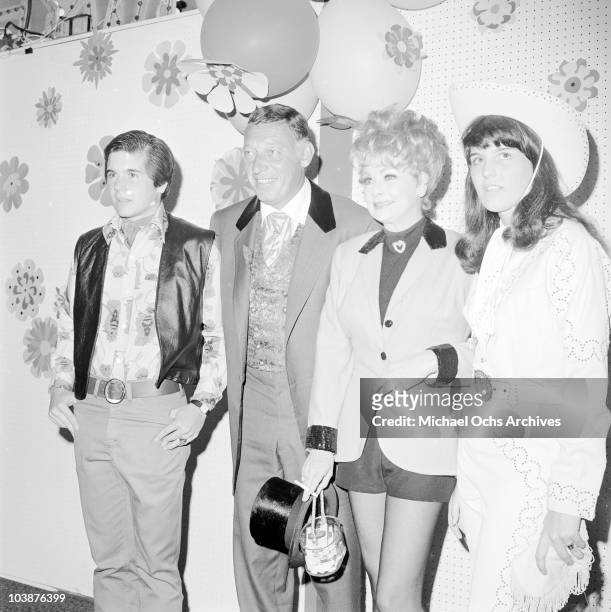 American actress Lucille Ball and her husband Gary Morton attend a charity fund-raising event in western-style costumes, circa 1965. With them are...