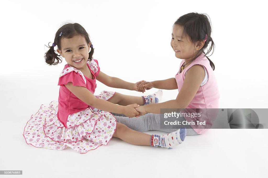 Two friends sitting down and playing