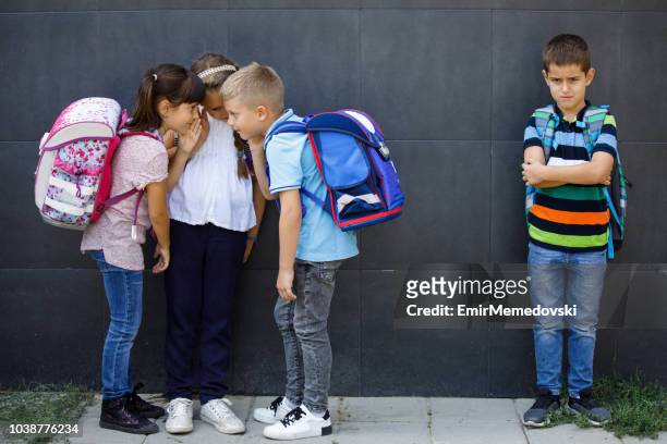 unhappy boy being gossiped about by school friends - exclusion stock pictures, royalty-free photos & images