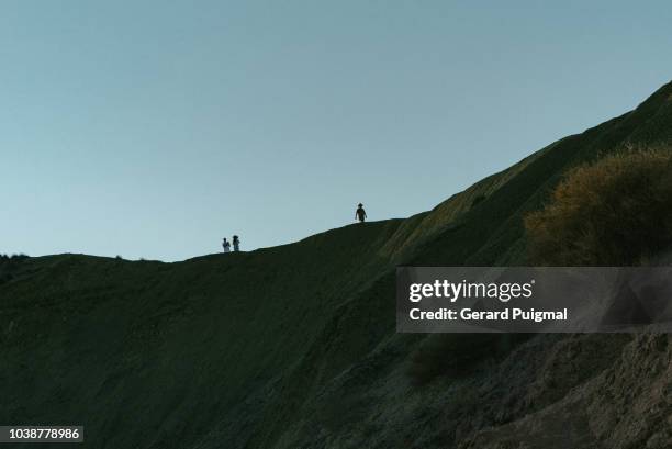 people walking on top of hills - malta wandern stock-fotos und bilder