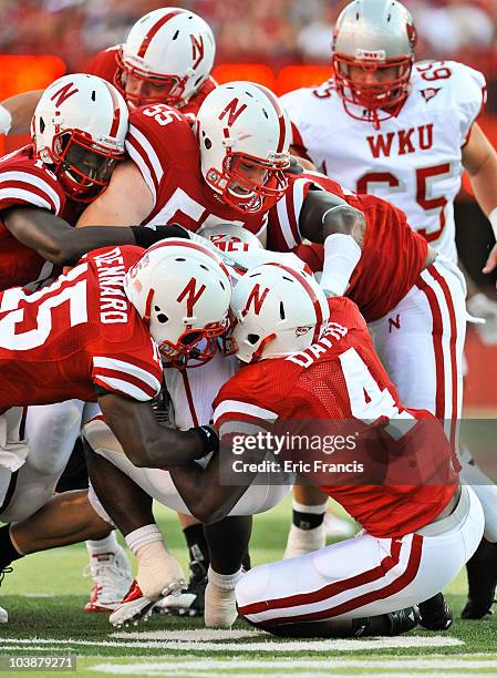 The Nebraska Cornhuskers defense swarms Bobby Rainey of the Western Kentucky Hilltoppers during the first half of their game at Memorial Stadium on...