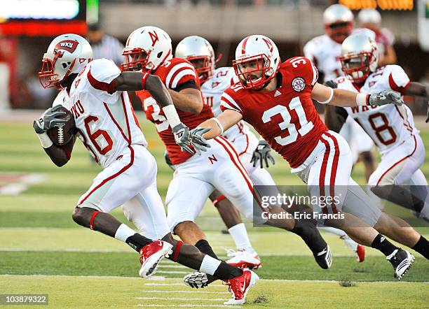 Willie McNeal of the Western Kentucky Hilltoppers attempts to out run Jase Dean of the Nebraska Cornhuskers after a mishandled punt during first half...