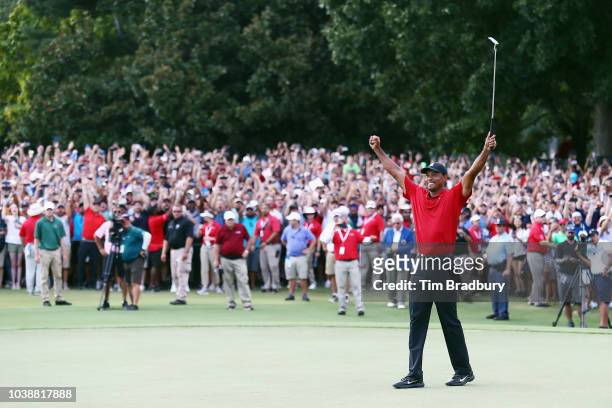 Tiger Woods of the United States celebrates making a par on the 18th green to win the TOUR Championship at East Lake Golf Club on September 23, 2018...