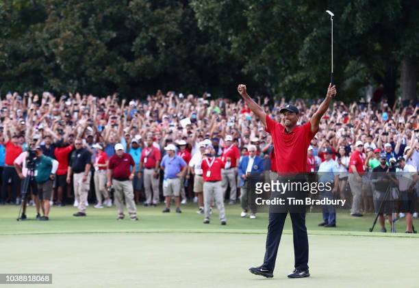 Tiger Woods of the United States celebrates making a par on the 18th green to win the TOUR Championship at East Lake Golf Club on September 23, 2018...