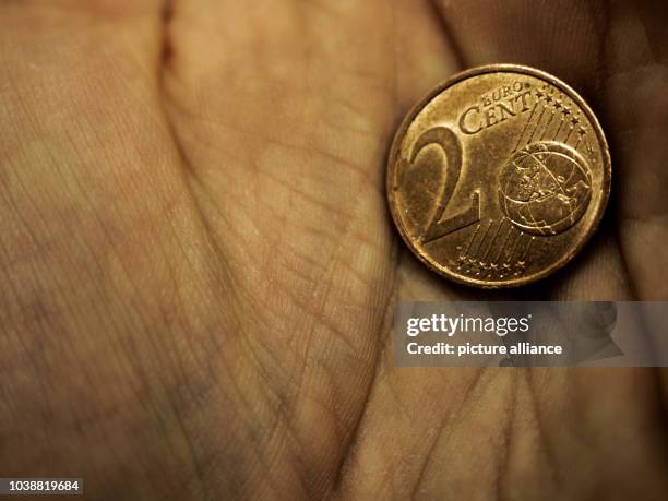 Two cent coin in the palm of hand in Bamberg, Germany, 21 February 2017. Photo: Nicolas Armer/dpa | usage worldwide