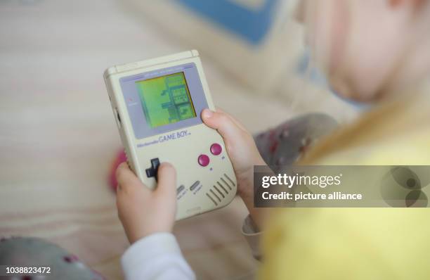 An illustrated picture shows a child playing the video game Tetris on a first generation Game Boy in Dresden, Germany, 28 April 2014. Photo: Thomas...