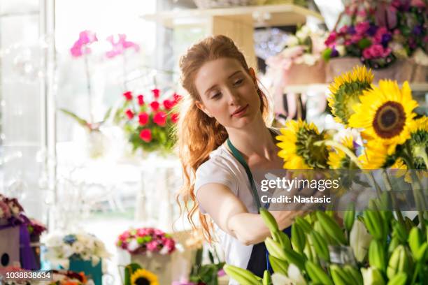 blumengeschäft, geführt von jungen frau - blumenhändler stock-fotos und bilder