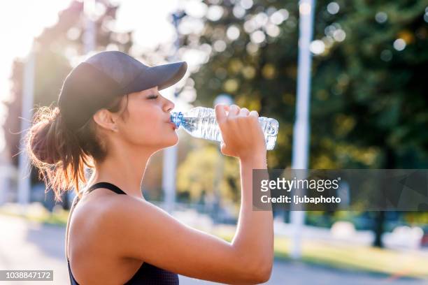 foto di sporty giovane donna acqua potabile - refreshment foto e immagini stock
