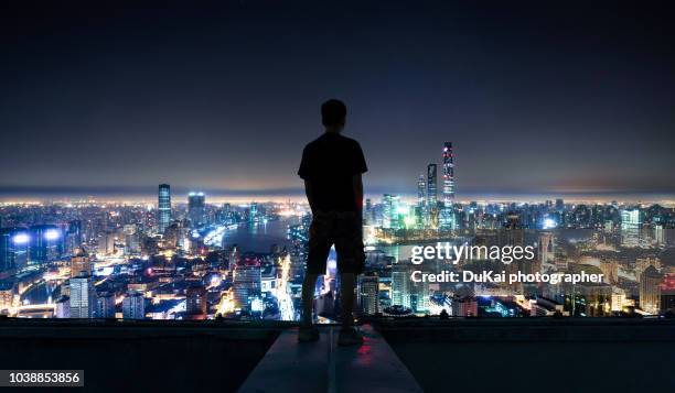 the young man stood on the roof and looked at the shanghai cbd - people shanghai stockfoto's en -beelden