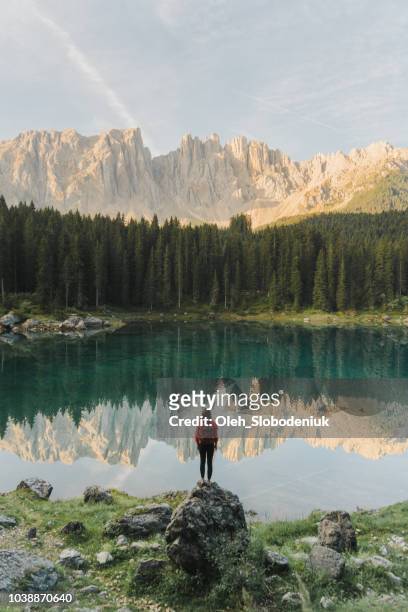 woman standing and looking at  lago di carezza in dolomites - alpen sommer stock pictures, royalty-free photos & images