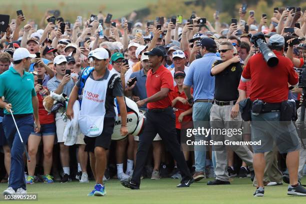 Tiger Woods of the United States is swarmed by fans as he walks to the 18th green during the final round of the TOUR Championship at East Lake Golf...