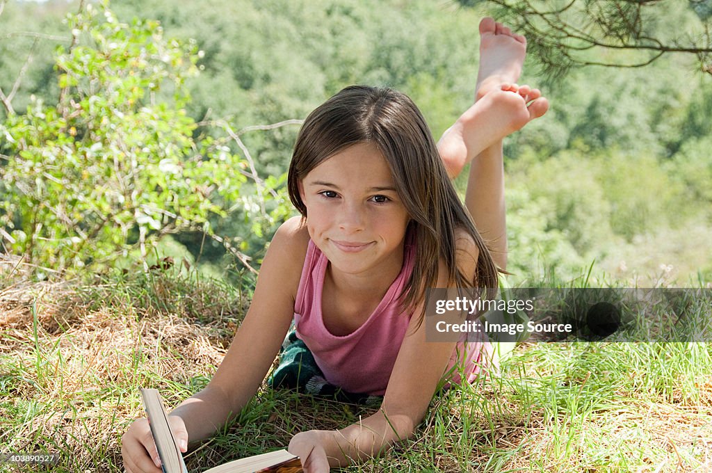 Girls lying on front with book