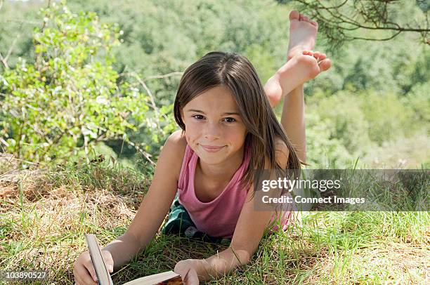 girls lying on front with book - barefoot girl stock pictures, royalty-free photos & images