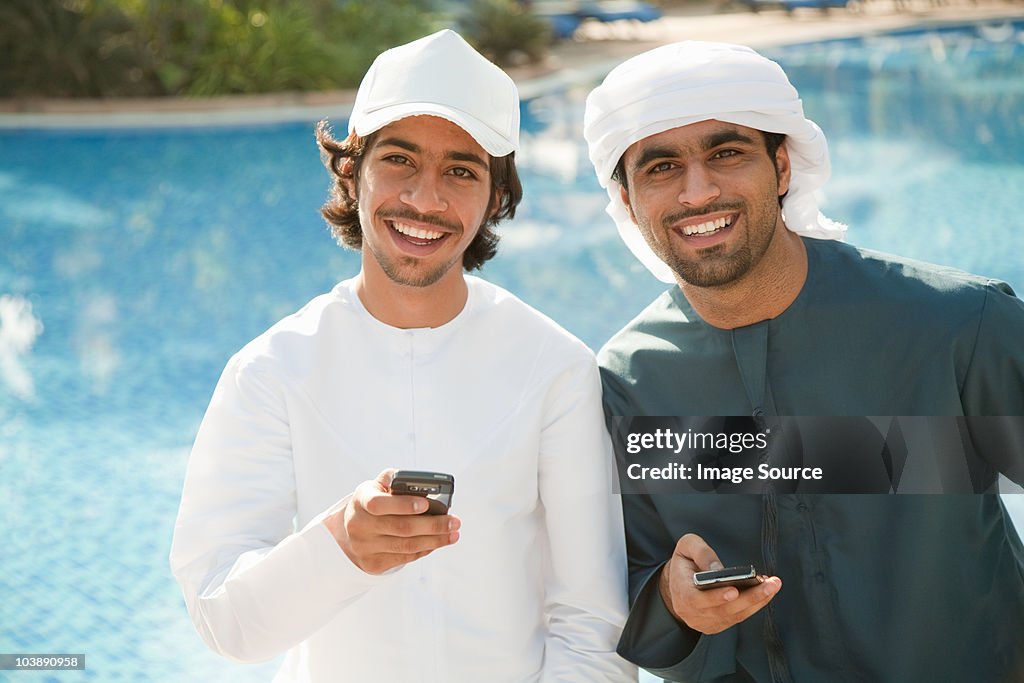 Two Middle Eastern men with mobile phones