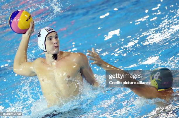 Julian Real of Germany and Aaron Younger of Australia vie for the ball during their Men's water polo quarterfinal match of the 15th FINA Swimming...