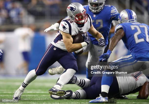 Rex Burkhead of the New England Patriots looks for yardage against Christian Jones of the Detroit Lions and Glover Quin during the first half at Ford...