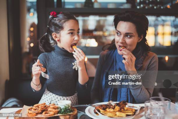 mother and daughter enjoying nice dinner together - eating seafood stock pictures, royalty-free photos & images