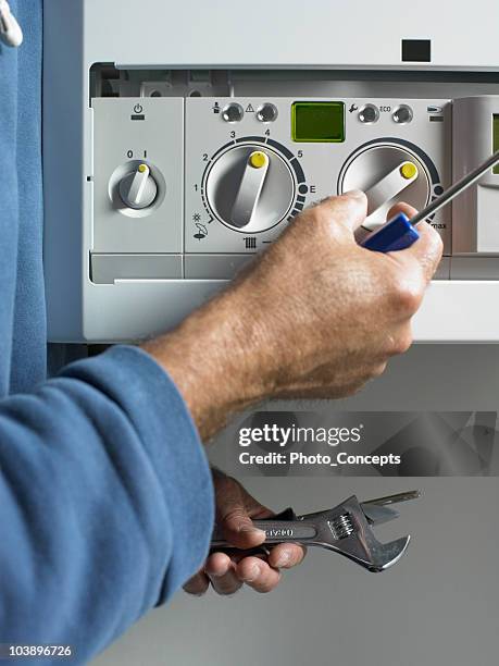 customer service man fixing boiler - boilers stock pictures, royalty-free photos & images