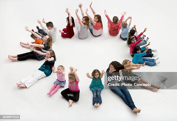 waving children sitting a circle. - children circle floor stock pictures, royalty-free photos & images