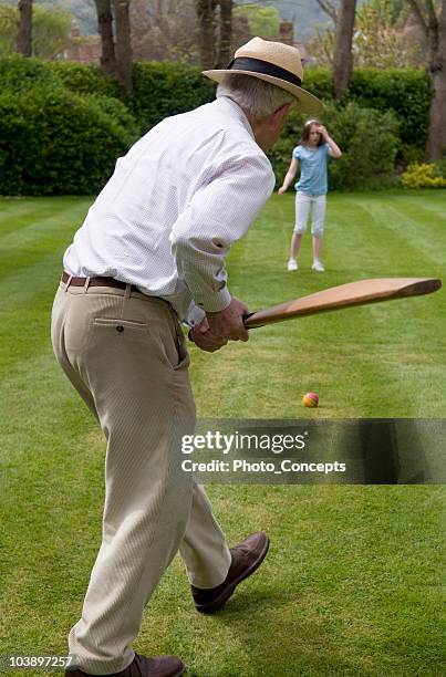 determined grandfather bonding and playing cricket in backyard with granddaughter - backyard cricket stock pictures, royalty-free photos & images