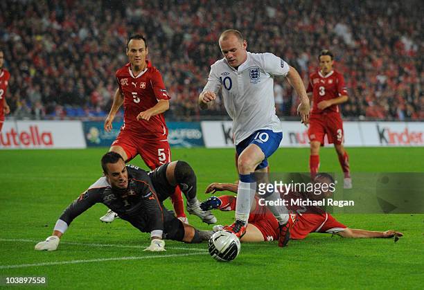 Wayne Rooney of England takes on Stephan Lichtsteiner, Steve von Bergen and Diego Benaglio of Switzerland during the EURO 2012 Group G Qualifier...