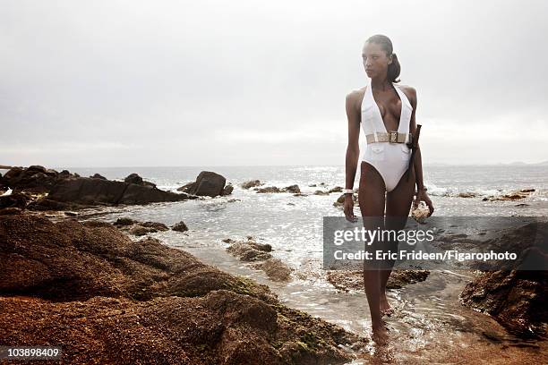 Model Noemi Lenoir at a James Bond inspired fashion session for Madame Figaro Magazine in 2009 in Corsica, France. Bathing suit by DSquared2, watch...