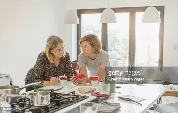 senior mother and daughter in kitchen - adult child stock pictures, royalty-free photos & images