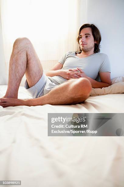 man relaxing in bed - lesbos stockfoto's en -beelden